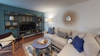 This two-story Shadowstone residence offers 2 bedrooms and 2.5 bathrooms thoughtfully distributed across two levels. The main living area centers around a tile-surround fireplace and opens toward a sliding glass door that floods the room with natural light and provides access to a private balcony. Wood-style flooring runs throughout the main level, connecting the living space to a dedicated dining area and a well-designed kitchen.

The kitchen features white shaker cabinetry, a mosaic tile backsplash, stainless steel appliances including a French door refrigerator and range, and a gray quartz peninsula with bar seating. Adjacent to the kitchen, the dining area comfortably accommodates a round table and additional storage. Recessed lighting throughout the main level enhances the bright, open atmosphere.

The primary bedroom is generously proportioned, finished with plush carpet, vaulted ceilings, a ceiling fan, and direct access to a private balcony with outdoor seating. The primary bathroom includes a walk-in shower with a glass enclosure. The second bedroom is well-sized and features neutral tones. A convenient half bathroom serves the main level, finished with a white vanity and gray countertop.
