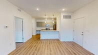 Located at 283 Capitol Avenue in Winder, GA, this well-appointed one-bedroom, one-bathroom residence offers a thoughtfully designed single-floor layout. Light-toned luxury vinyl plank flooring runs throughout the entire space, creating a cohesive and contemporary feel.

The open-concept kitchen and living area serves as the heart of the home. The kitchen features a large granite-topped island with an undermount sink, modern gray shaker-style cabinetry, stainless steel appliances including a range, microwave, and refrigerator, and stylish pendant lighting overhead. The living area extends generously from the kitchen and includes a ceiling fan and sliding glass doors that open to an outdoor balcony, allowing for natural light and exterior views.

The spacious primary bedroom offers comfortable proportions and convenient access to a walk-in closet outfitted with wire shelving systems for organized storage. The full bathroom is clean and functional, featuring granite-topped vanity cabinetry with brushed nickel hardware, a tub-shower combination, and matching vinyl plank flooring. A dedicated entry area with recessed lighting and a security system completes the layout, providing a clean transition into the home.