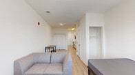 Located at 221 Waldron St in West Lafayette, Indiana, this efficiently designed single-floor unit offers a thoughtfully organized layout that maximizes every square foot. The open-plan living, dining, and kitchen area forms the heart of the space, finished with light hardwood-style flooring and crisp white walls that create a bright, clean aesthetic throughout.

The kitchen is well-appointed with gray shaker-style cabinetry accented by matte black hardware, white quartz-look countertops, and a classic subway tile backsplash. Stainless steel appliances — including a refrigerator, dishwasher, and range — along with a stainless sink provide a fully functional cooking space. Overhead, a skylight-style flush fixture ensures excellent task lighting.

The living and dining area is open and versatile, with a window allowing natural light to fill the room. Two closets offer ample storage, complementing the efficient use of space throughout. Two bathrooms, finished with the same light flooring and clean white walls, provide practical convenience. A dedicated laundry area adds further functionality to the unit.

The overall design emphasizes a modern, neutral palette with consistent finishes, making the space feel cohesive and move-in ready. This unit is well-suited for those seeking a streamlined, contemporary living environment in the West Lafayette area.