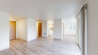 This single-floor, 2-bedroom, 1-bathroom residence offers a clean, functional layout designed for comfortable everyday living. The open-plan living and dining areas are bathed in natural light, courtesy of large windows and a sliding glass door that leads to a private balcony overlooking a landscaped outdoor setting. Light-toned laminate flooring runs throughout the main living spaces, contributing to the bright, airy feel of the interior.

The kitchen is efficiently designed with ample wood-trimmed cabinetry in white, generous countertop space, and a full suite of white appliances including a dishwasher, range, and refrigerator. A pass-through peninsula adds additional workspace and visual connection to the living area.

Both bedrooms are carpeted for warmth and comfort, each featuring sliding wood-paneled closet doors. The primary bedroom is a comfortable size with its own closet and direct access to the hallway. Altogether, the unit includes six closets, providing exceptional storage throughout.

The bathroom is neatly appointed with a wide vanity topped with a stone-look countertop, a large mirror, and a full tub-shower combination. Additional conveniences include an in-unit laundry area. The neutral color palette and clean finishes throughout give the space a fresh, move-in-ready appearance.