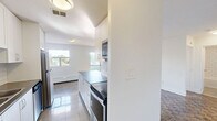 Located at 7 Albert St in Whitchurch-Stouffville, Ontario, this well-appointed one-bedroom, one-bathroom unit offers a thoughtfully designed single-floor layout. The space is finished with rich parquet hardwood flooring throughout the living and bedroom areas, adding warmth and character to the clean, neutral interior palette.

The kitchen is a functional galley-style space featuring crisp white cabinetry, classic subway tile backsplash, dark countertops, and a full suite of stainless steel appliances including a refrigerator, stove, microwave, and dishwasher. Gleaming large-format tile flooring and ample cabinetry make this kitchen both practical and visually appealing.

The bedroom is a comfortable, well-sized room bathed in natural light from a bright window with outdoor views. A built-in mirrored sliding closet adds storage while enhancing the sense of space. A baseboard heating unit runs along the wall, ensuring year-round comfort.

The bathroom is finished with bright white subway tile surrounding a full soaker tub and shower combination, creating a clean and timeless aesthetic.

Throughout the unit, the white walls and abundant natural light contribute to an airy, fresh ambiance. This unit is a well-maintained, move-in ready home in a convenient Whitchurch-Stouffville location.