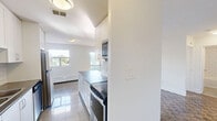 Located at 7 Albert St in Whitchurch-Stouffville, Ontario, this well-appointed one-bedroom, one-bathroom unit offers a thoughtfully designed single-floor layout. The space is finished with rich parquet hardwood flooring throughout the living and bedroom areas, adding warmth and character to the clean, neutral interior palette.

The kitchen is a functional galley-style space featuring crisp white cabinetry, classic subway tile backsplash, dark countertops, and a full suite of stainless steel appliances including a refrigerator, stove, microwave, and dishwasher. Gleaming large-format tile flooring and ample cabinetry make this kitchen both practical and visually appealing.

The bedroom is a comfortable, well-sized room bathed in natural light from a bright window with outdoor views. A built-in mirrored sliding closet adds storage while enhancing the sense of space. A baseboard heating unit runs along the wall, ensuring year-round comfort.

The bathroom is finished with bright white subway tile surrounding a full soaker tub and shower combination, creating a clean and timeless aesthetic.

Throughout the unit, the white walls and abundant natural light contribute to an airy, fresh ambiance. This unit is a well-maintained, move-in ready home in a convenient Whitchurch-Stouffville location.