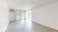 Located at 3301 Yorba Linda Blvd in Fullerton, CA, this two-bedroom, one-bathroom single-floor residence offers a clean, functional layout with a bright and neutral aesthetic throughout. Wood-look flooring extends across the entire unit, lending a cohesive and low-maintenance appeal to every room.

The combined kitchen and living area forms the heart of the home. The kitchen is equipped with stainless steel appliances — including a gas range and full-size refrigerator — white cabinetry, and a wall-mounted range hood. The adjacent living room is generously sized, featuring large sliding glass doors dressed with vertical blinds that invite abundant natural light and offer views of the surrounding greenery and pool area. A wall-mounted air conditioning unit keeps the space comfortable year-round.

Both bedrooms continue the wood-look flooring and white wall palette. The primary bedroom includes a ceiling fan with integrated lighting, a closet with sliding doors, and access to the outdoors via a sliding glass door. The second bedroom also features a built-in closet with sliding panel doors. A dedicated hallway closet provides additional storage.

The full bathroom includes a combination tub and shower, a vanity with a stone-look countertop, and a large mirror. The space is clean, practical, and move-in ready.