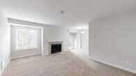 Located in Bothell, WA, this well-appointed 1-bedroom, 1-bathroom residence offers a thoughtfully designed single-floor layout that maximizes comfort and functionality. The living room serves as the heart of the home, featuring plush wall-to-wall carpeting, a charming stone-surround fireplace with a white mantel, and natural light streaming in through multiple windows. A sliding glass door provides direct outdoor access, enhancing the open, airy feel of the space. The kitchen is equipped with rich warm-toned wood cabinetry extending to the ceiling, granite countertops, a tile backsplash, stainless steel appliances, and wood-look flooring. A skylight adds brightness to the cooking area. The bedroom offers a comfortable retreat with soft carpeting, a window with outdoor views, and a spacious walk-in closet with built-in shelving. The bathroom features a clean, bright design with a full soaking tub and shower combination, wood-look tile flooring, and dark bronze hardware accents. A connecting hallway ties the rooms together efficiently, completing this practical and inviting home in Bothell.