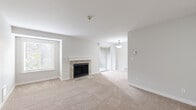 Located in Bothell, WA, this well-appointed 1-bedroom, 1-bathroom residence offers a thoughtfully designed single-floor layout that maximizes comfort and functionality. The living room serves as the heart of the home, featuring plush wall-to-wall carpeting, a charming stone-surround fireplace with a white mantel, and natural light streaming in through multiple windows. A sliding glass door provides direct outdoor access, enhancing the open, airy feel of the space. The kitchen is equipped with rich warm-toned wood cabinetry extending to the ceiling, granite countertops, a tile backsplash, stainless steel appliances, and wood-look flooring. A skylight adds brightness to the cooking area. The bedroom offers a comfortable retreat with soft carpeting, a window with outdoor views, and a spacious walk-in closet with built-in shelving. The bathroom features a clean, bright design with a full soaking tub and shower combination, wood-look tile flooring, and dark bronze hardware accents. A connecting hallway ties the rooms together efficiently, completing this practical and inviting home in Bothell.