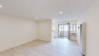 Located at 21431 Saticoy St in Canoga Park, CA, this thoughtfully designed one-bedroom, two-bathroom unit offers a clean, modern aesthetic throughout its efficiently organized single-floor layout. Light wood-style flooring flows seamlessly through every room, complemented by crisp white walls and recessed lighting that keep the space feeling bright and airy.

The open living area provides a comfortable footprint with ample room for seating and everyday use. Recessed lighting overhead adds a contemporary touch, while a entry door with gold-tone hardware adds a subtle accent. The kitchen is well-appointed with white shaker cabinetry featuring brushed gold pulls, light countertops, a gas range, and a sink — all arranged efficiently for ease of use.

The bedroom offers a comfortable retreat, complete with a window that brings in natural light, recessed ceiling lights, and a mirrored sliding closet that enhances the sense of space. Two bathrooms provide added convenience, each finished in a neutral palette consistent with the rest of the unit.

The building itself features a stucco exterior typical of Southern California residential architecture. With its refreshed interior finishes and clean, minimalist presentation, this unit offers a move-in-ready living experience in the heart of the San Fernando Valley.