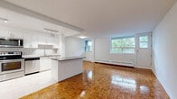 This well-appointed 2-bedroom, 1-bathroom unit at 739 Birchmount Road, Suite 310, in Toronto's Scarborough neighbourhood offers a comfortable and functional layout across a single floor. Warm, patterned parquet hardwood flooring runs throughout the living areas and bedrooms, lending a classic character to the space.

The kitchen has been thoughtfully renovated with crisp white cabinetry, a herringbone-patterned tile backsplash, dark countertops, and a full suite of stainless steel appliances including a refrigerator, stove, built-in microwave, and dishwasher. Track lighting illuminates the space, which transitions seamlessly into the living area via a breakfast bar overhang.

The living room is bright and open, with large windows that invite natural light and offer calming views of mature trees and the surrounding neighbourhood. The primary bedroom is generously sized, featuring a mirrored sliding closet and its own window with greenery views. The second bedroom is equally well-lit with its own window and baseboard heating.

The bathroom is finished with clean white subway tile surrounding a full soaker tub, complemented by a stone-finish vanity countertop. A private balcony with glass railing provides a peaceful outdoor retreat overlooking lush treetops.