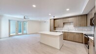 Located at 425 Centerpointe Circle in Altamonte Springs, FL, this modern 2-bedroom, 2-bathroom residence offers a thoughtfully designed single-floor layout with clean, contemporary finishes throughout. Light wood-look flooring flows seamlessly across the open-concept living, dining, and kitchen area, creating a bright and cohesive atmosphere. The kitchen is a standout feature, showcasing warm-toned flat-front cabinetry, crisp white quartz countertops, a textured tile backsplash, a central island, and a full suite of stainless steel appliances including a refrigerator with ice maker, dishwasher, and range. Recessed lighting and a ceiling fan enhance the expansive main living area, which opens to an outdoor balcony through sliding glass doors, bringing in natural light and outdoor views of the surrounding landscape. The generously sized primary bedroom includes a walk-in closet with wire shelving and direct balcony access. The second bedroom benefits from large windows that invite natural light. Both bathrooms are finished with marble-style tile flooring, wood-toned vanities, white quartz countertops, and frameless glass-enclosed showers. Additional conveniences include a dedicated laundry area and utility room, plus two closets providing ample storage throughout.