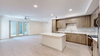Located at 425 Centerpointe Circle in Altamonte Springs, FL, this modern 2-bedroom, 2-bathroom residence offers a thoughtfully designed single-floor layout with clean, contemporary finishes throughout. Light wood-look flooring flows seamlessly across the open-concept living, dining, and kitchen area, creating a bright and cohesive atmosphere. The kitchen is a standout feature, showcasing warm-toned flat-front cabinetry, crisp white quartz countertops, a textured tile backsplash, a central island, and a full suite of stainless steel appliances including a refrigerator with ice maker, dishwasher, and range. Recessed lighting and a ceiling fan enhance the expansive main living area, which opens to an outdoor balcony through sliding glass doors, bringing in natural light and outdoor views of the surrounding landscape. The generously sized primary bedroom includes a walk-in closet with wire shelving and direct balcony access. The second bedroom benefits from large windows that invite natural light. Both bathrooms are finished with marble-style tile flooring, wood-toned vanities, white quartz countertops, and frameless glass-enclosed showers. Additional conveniences include a dedicated laundry area and utility room, plus two closets providing ample storage throughout.