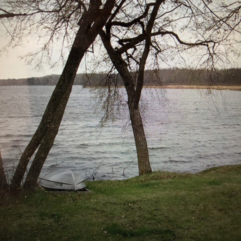 Holt Lake with small fishing boat in front of cabin. - 26437 Linden street