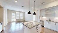Located at 1012 Burnett St in Fort Worth, TX, this well-appointed 2-bedroom, 1-bathroom residence offers a thoughtfully designed single-level layout with modern finishes throughout. The open-concept kitchen and living area serves as the heart of the home, featuring white shaker cabinetry with matte black hardware, striking granite countertops, a classic white subway tile backsplash, stainless steel appliances, and a central island with pendant lighting — ideal for both everyday living and entertaining. Light wood-style flooring flows through the main living areas, adding warmth and continuity to the space. The generously sized primary bedroom is a standout, offering plush carpeting, a ceiling fan, and a wall of tall windows with blinds that invite ample natural light. It connects directly to the full bathroom, which features a soaking tub framed by large-format tile surround with a built-in niche, as well as a dedicated closet with shelving. The second bedroom also offers carpet flooring, natural light from windows, and access to an outdoor balcony through a glass door. Clean white walls and crisp trim throughout give the entire residence a bright, contemporary aesthetic suited to modern living.