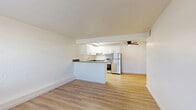 Located at 3660 E 3rd St in Tucson, AZ, this one-bedroom, one-bathroom unit offers a well-organized single-floor layout that maximizes every square foot. The open-concept kitchen and living area serves as the heart of the unit, featuring light wood-tone luxury vinyl plank flooring that flows throughout. The kitchen is outfitted with crisp white shaker-style cabinetry, dark countertops, a stainless steel refrigerator, range, and dishwasher, complemented by a white tile backsplash. The living area is bright and airy, with large windows fitted with blinds that invite natural light and outdoor views of the surrounding greenery. Painted block walls add subtle texture to the space, giving it a distinct character. A ceiling fan with light fixture provides both comfort and illumination. The bedroom is a well-proportioned retreat featuring a double-door closet, painted block accent walls, and a window with views of the outdoors. A connecting hallway links the bedroom to the bathroom, which includes a tub-shower combo with full beige tile surround, wood-tone flooring, and white vanity cabinetry. Throughout the unit, clean white walls and consistent flooring create a cohesive, move-in-ready atmosphere.