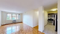 Located at 175 Freeman St, Unit 823 in Brookline, MA, this one-bedroom, one-bathroom residence offers a well-organized layout across a single floor. The living room is a bright, open space featuring gleaming parquet hardwood flooring and large windows that invite generous natural light and views of the surrounding neighborhood. A baseboard heating system and wall-mounted AC unit provide year-round climate control.

The kitchen is efficiently designed with dark espresso cabinetry, stainless steel appliances including a gas range, microwave, and refrigerator, complemented by light tile flooring and open shelving for additional storage. A hallway connects the main living areas and provides a smooth flow throughout the unit.

The bedroom is a comfortable, well-proportioned room also featuring parquet hardwood floors, a large window with outdoor views, and an expansive built-in closet system offering ample storage space. The bathroom is clean and functional, featuring a wide vanity with an undermount sink, a large mirror, and a rich wood-toned vanity cabinet. Crisp white walls throughout the unit contribute to a bright, neutral palette ready for personalization.