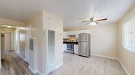 Located at 2211 Redwood St in Vallejo, CA, this thoughtfully designed residence offers three bedrooms and two bathrooms across a single level. The interior is finished with light-toned luxury vinyl plank flooring throughout the living areas and bedrooms, complemented by warm beige walls that create a clean, welcoming ambiance.

The combined kitchen and living area serves as the heart of the home. The kitchen is equipped with stainless steel appliances — including a refrigerator and range — white shaker-style cabinetry, dark stone countertops, and a stainless steel sink. The adjacent living area features a ceiling fan, natural light from a front-facing window, and tile flooring that ties the space together seamlessly.

Each of the three bedrooms is well-proportioned, featuring vinyl plank flooring, neutral walls, and windows that allow natural light and outdoor views. The primary bedroom includes a closet with double panel doors and direct access to a hallway.

Both bathrooms are finished with white vanities, dark stone countertops, and brushed nickel fixtures. The full bath features a tiled tub-surround with a decorative mosaic accent border, adding a refined touch. Light tile flooring completes the clean, modern aesthetic of each bathroom.