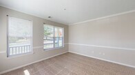 This single-floor residence at The Point at Pine Ridge in Coram, New York offers a well-designed layout with a seamless flow between living spaces. The expansive living and dining area is finished with soft, plush carpeting and neutral-toned walls, creating a bright and welcoming atmosphere. Large windows allow generous natural light to fill the space, with views of the surrounding greenery and community grounds.

The kitchen is equipped with ample white cabinetry, a gas range, an over-the-range microwave, and light-toned countertops with a tile backsplash, providing a clean and functional workspace.

The bedrooms are generously proportioned, each featuring wall-to-wall carpeting, neutral painted walls, and large windows that invite natural light and outdoor views. One bedroom includes a walk-in closet, adding practical storage.

The primary bathroom features a dual-sink vanity with white cabinetry, tile flooring, a well-lit mirror, and a separate closet area. A second full bathroom provides a single-sink vanity, tile flooring, a toilet, and a shower/tub combination, maintaining a consistent clean aesthetic throughout.

Overall, the residence presents a comfortable and functional living environment with a cohesive neutral palette, plentiful natural light, and thoughtful use of space throughout every room.