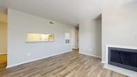 This single-story unit in Arlington, Texas offers a practical and well-organized layout across two bedrooms and one bathroom. The living room serves as the central gathering space, featuring wood-look tile flooring, neutral gray walls, a textured ceiling, and a wood-burning fireplace flanked by a large window that brings in natural light and outdoor views. A pass-through window connects the living area to the kitchen, enhancing the open feel between the two spaces.

The kitchen is equipped with white cabinetry, white appliances including a refrigerator and electric range, light wood-look flooring, and ample counter space along its perimeter layout. A hallway leads from the main living area to the private quarters of the unit.

Both bedrooms feature neutral carpet flooring, ceiling fans with light fixtures, and textured ceilings. The primary bedroom offers a comfortable footprint with closet access, while the second bedroom also includes a window for natural light. Two closets throughout the unit provide dedicated storage.

The bathroom includes wood-look tile flooring, a tub-shower combination, and clean white finishes, maintaining the consistent neutral palette found throughout the space.