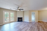 Located at 315 Flint Hill Rd in Fort Mill, SC, this well-appointed one-bedroom, one-bathroom home offers a thoughtfully designed single-floor layout. The open-concept living area serves as the heart of the home, featuring light gray luxury vinyl plank flooring, a textured ceiling with a ceiling fan, and a sleek fireplace with a tile surround. French doors flood the space with natural light and provide direct access to a private outdoor deck, offering pleasant outdoor views. Adjacent to the living room, the dining area is defined by warm wood-toned LVP flooring and an elegant multi-arm chandelier, creating an inviting atmosphere for meals. The kitchen features warm wood cabinetry, granite-style countertops, a peninsula with a matte black faucet, white appliances, and track lighting overhead. A hallway connects the main living areas to the private bedroom, which is carpeted and includes a ceiling fan, natural light from a window with outdoor views, and access to a closet. The bathroom is finished with wood-toned cabinetry, a granite vanity top, LVP flooring, and a tub/shower combination. Neutral tones and consistent finishes throughout create a cohesive and comfortable living environment.