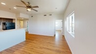 Located in Phoenix, AZ, this single-floor, three-bedroom, two-bathroom home offers a well-organized layout with consistent warm wood-style flooring throughout. The open-concept kitchen and living area serves as the heart of the home, featuring a spacious U-shaped kitchen equipped with dark wood-grain cabinetry, white countertops, black appliances including a refrigerator, range, and built-in microwave, and recessed lighting overhead. A breakfast bar peninsula connects the kitchen to the living area, which is brightened by large windows and a ceiling fan.

Each of the three bedrooms is finished with the same wood-style flooring, ceiling fans, and white walls, creating a clean, neutral aesthetic. The primary bedroom offers multiple windows with views of the surrounding Phoenix neighborhood, including palm trees and nearby rooftops. The additional bedrooms also feature closets and natural light.

The two bathrooms are simply appointed with wood-grain vanity cabinetry, white countertops, and mirrors. One bathroom includes a walk-in shower, while the other features a full soaking tub and shower combination. Both maintain the clean, minimal design seen throughout the home. The overall ambiance is bright, functional, and move-in ready.