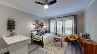 Located at 2400 N Lakeview Ave in Chicago's sought-after Lincoln Park neighborhood, this well-appointed studio offers a smart, efficient layout with modern finishes throughout. The main living area serves as both a sleeping and lounge space, featuring wood-look flooring, crown molding, and a ceiling fan with integrated lighting. A bank of windows with blinds allows for generous natural light, while a cozy seating arrangement with a warm accent chair and round coffee table adds functional comfort to the room.

The kitchen is neatly tucked behind a framed opening and equipped with white shaker cabinetry, a stainless steel gas range, a refrigerator, and a stainless steel sink set into marble-look countertops. A distinctive blue subway tile backsplash adds a refined design touch. Adjacent to the kitchen, a compact breakfast bar with seating provides a casual dining option.

A separate dining nook features a wooden table with modern chairs, open floating shelves for display and storage, and direct access to a spacious closet. The bathroom includes a vanity with ample storage. Crown molding, consistent flooring, and a neutral gray-toned palette tie the space together, creating a cohesive and inviting urban retreat.