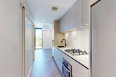 Located at 1320 4th St NE in Washington, DC, this modern one-bedroom, one-bathroom unit offers a well-designed layout across a single floor. The galley-style kitchen is outfitted with light wood cabinetry extending to the ceiling, a gas cooktop, stainless steel appliances including a refrigerator and oven, a matte black faucet, and clean white countertops — all illuminated by under-cabinet lighting. Light hardwood flooring flows throughout the unit, lending warmth and continuity to each room. The combined dining and living area benefits from dramatic floor-to-ceiling windows that frame outdoor views and flood the space with natural light. The bedroom is a bright, intimate retreat with a sliding closet and its own access to expansive glazing, offering additional natural light and open views. Two closets provide practical storage throughout the unit, complemented by a dedicated laundry area and utility room. The bathroom features a tub-shower combo with white subway tile, matte black fixtures, a wood-toned vanity with an integrated sink, and distinctive hexagonal floor tile, creating a stylish yet functional space. A clean hallway connects all areas cohesively, completing this efficiently designed urban residence.