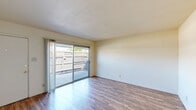 Located at 295 E Olive Ave in Merced, California, this single-story 2-bedroom, 1-bathroom residence offers a practical and well-organized layout. Wood-style flooring runs consistently throughout the home, lending a cohesive and easy-to-maintain aesthetic across all rooms.

The galley-style kitchen is equipped with warm honey-toned wood cabinetry, tile countertops, and white appliances including a refrigerator, electric range, and dishwasher. A window above the counter allows natural light to brighten the workspace.

The living room is a comfortable, open area highlighted by a full-width sliding glass door that leads to an outdoor patio space, providing an abundance of natural light and outdoor connectivity.

The spacious primary bedroom features a wide window for natural light and a sliding-door closet, offering generous storage. The second bedroom is similarly well-lit with a large window and neutral walls. Both rooms are finished with light wood-style flooring.

The bathroom includes a tiled tub-shower combination with a curved curtain rod and standard fixtures. A dedicated closet provides additional storage within the unit. The overall design is clean, neutral, and functional, making this residence a straightforward and comfortable living space.