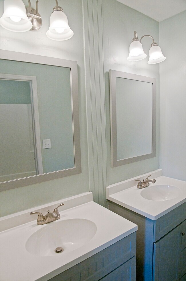El baño principal cuenta con dos lavabos. El inodoro y la ducha/bañera se encuentran en una habitación separada. - 409 Erskine St