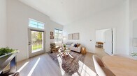 Located at 339 Boston Post Rd in Marlborough, MA, this thoughtfully designed 2-bedroom, 2-bathroom residence offers a bright and airy atmosphere throughout. Soaring ceilings and light wood flooring flow seamlessly across the open floor plan, creating an inviting sense of spaciousness.

The combined kitchen and living area serves as the heart of the home. The kitchen features crisp white cabinetry, a subway tile backsplash, quartz countertops, stainless steel appliances, and a generous waterfall island with seating — ideal for both cooking and entertaining. The living area is bathed in natural light from large windows and a glass door that opens directly to a private patio overlooking a lush green yard.

Both bedrooms are well-proportioned and sun-filled, with the primary bedroom offering a comfortable, tranquil retreat. The two bathrooms are finished with clean, contemporary tile work, including a glass-enclosed walk-in shower. Three closets provide ample storage throughout the residence.

Additional practical spaces include a dedicated laundry room and a utility room. The clean white palette, high ceilings, and abundance of natural light give the entire home a modern, welcoming ambiance that is both functional and elegant.