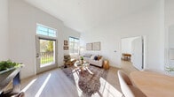 Located at 339 Boston Post Rd in Marlborough, MA, this thoughtfully designed 2-bedroom, 2-bathroom residence offers a bright and airy atmosphere throughout. Soaring ceilings and light wood flooring flow seamlessly across the open floor plan, creating an inviting sense of spaciousness.

The combined kitchen and living area serves as the heart of the home. The kitchen features crisp white cabinetry, a subway tile backsplash, quartz countertops, stainless steel appliances, and a generous waterfall island with seating — ideal for both cooking and entertaining. The living area is bathed in natural light from large windows and a glass door that opens directly to a private patio overlooking a lush green yard.

Both bedrooms are well-proportioned and sun-filled, with the primary bedroom offering a comfortable, tranquil retreat. The two bathrooms are finished with clean, contemporary tile work, including a glass-enclosed walk-in shower. Three closets provide ample storage throughout the residence.

Additional practical spaces include a dedicated laundry room and a utility room. The clean white palette, high ceilings, and abundance of natural light give the entire home a modern, welcoming ambiance that is both functional and elegant.