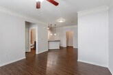 Located at 10609 W 134th St in Overland Park, Kansas, this single-floor residence offers a thoughtfully designed layout with a blend of comfort and functionality. The open living and dining areas are finished with rich, dark hardwood flooring and accented by crown molding throughout, creating a polished, cohesive aesthetic. Ceiling fans are present in the main living spaces, providing both style and practicality. French doors in the living area invite natural light and offer access to the exterior.

The kitchen is well-appointed with rich, dark wood cabinetry, granite-style dark countertops, a tile backsplash, and a full suite of stainless steel appliances including a range, built-in microwave, and dishwasher. A breakfast bar peninsula connects the kitchen to the living area, making it an ideal space for casual dining and entertaining.

The bedrooms are carpeted for comfort and each feature ceiling fans, crown molding, and closet space. The bathroom is cleanly finished with tile-surround tub and shower combination, dark wood vanity with granite-style countertop, and hardwood-style flooring. The overall ambiance of this home is warm and inviting, with consistent finishes that lend a sense of quality and care throughout every room.