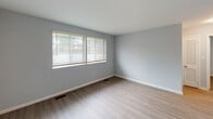 Located at 3300 Old Forest Rd in Lynchburg, Virginia, this single-floor residence offers a clean, updated interior with a neutral color palette of soft blue-gray walls and bright white trim throughout. The layout, as seen in the floor plan, includes a living area, kitchen, bathroom, and multiple bedrooms, all arranged for functional single-level living.

The living area is finished with light-toned wood-look flooring and features a large double window fitted with horizontal blinds, allowing ample natural light to fill the space. The kitchen is well-appointed with white cabinetry, laminate countertops, and a full suite of stainless steel appliances including a refrigerator, electric range, and dishwasher. A window above the sink brings in additional natural light and ventilation.

The bedrooms feature wall-to-wall carpeting in a warm tan tone, providing a comfortable and quiet atmosphere. Each bedroom is equipped with multiple windows dressed with horizontal blinds, ensuring good natural light and privacy. The bathroom includes a full soaking tub with a tiled surround, an overhead shower, and a window for natural ventilation.

Throughout the unit, consistent finishes — including updated flooring, fresh paint, and modern fixtures — give the space a cohesive, move-in ready feel.