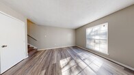 This two-story home at 515 Sykes Rd in Jackson, Mississippi offers a well-organized layout across two equally sized floors, providing comfortable living with 2 bedrooms and 2 bathrooms. The main floor welcomes you with a bright living room featuring wood-style plank flooring, neutral warm-toned walls, and a large window that fills the space with natural light. A staircase connects the two floors, with a second living area offering additional flexible space. The galley-style kitchen is outfitted with white cabinetry, white countertops, and matching white appliances, including a full-size refrigerator, all complemented by light wood-style flooring. Both bathrooms are clean and functional — one features a pedestal sink with a medicine cabinet mirror, while the other includes a full vanity with a tub-shower combination. The bedrooms are carpeted for comfort, each benefiting from natural light through well-positioned windows. The primary bedroom offers a generous footprint, providing ample space for furnishings. Throughout, the home maintains a consistent neutral color palette, creating a clean and move-in-ready atmosphere suited for a variety of living arrangements.