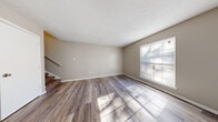 This two-story home at 515 Sykes Rd in Jackson, Mississippi offers a well-organized layout across two equally sized floors, providing comfortable living with 2 bedrooms and 2 bathrooms. The main floor welcomes you with a bright living room featuring wood-style plank flooring, neutral warm-toned walls, and a large window that fills the space with natural light. A staircase connects the two floors, with a second living area offering additional flexible space. The galley-style kitchen is outfitted with white cabinetry, white countertops, and matching white appliances, including a full-size refrigerator, all complemented by light wood-style flooring. Both bathrooms are clean and functional — one features a pedestal sink with a medicine cabinet mirror, while the other includes a full vanity with a tub-shower combination. The bedrooms are carpeted for comfort, each benefiting from natural light through well-positioned windows. The primary bedroom offers a generous footprint, providing ample space for furnishings. Throughout, the home maintains a consistent neutral color palette, creating a clean and move-in-ready atmosphere suited for a variety of living arrangements.