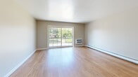 Located at 300 Glen Meadow Rd in Franklin, MA, this one-bedroom, one-bathroom residence offers a well-designed, single-floor layout with a cohesive and functional flow throughout. Light-toned hardwood flooring extends continuously across all living areas, creating a warm and unified aesthetic.

The combined kitchen and living room forms the heart of the home. The living area is bright and open, anchored by large sliding glass doors that lead to a private balcony and frame lush outdoor greenery, flooding the space with natural light. A wall-mounted HVAC unit and baseboard heating ensure year-round comfort. A pass-through window connects the living area to the kitchen, which features warm wood cabinetry, granite-look countertops, a stainless steel electric range, and a built-in microwave — providing a practical and attractive cooking environment.

The bedroom is a comfortable, well-proportioned room with a double window overlooking the outdoors and baseboard heating. It is serviced by a dedicated closet. The bathroom is clean and classic in design, featuring full white tile surround walls, a shower-tub combination, and wood-toned flooring. The entryway area provides additional access points and benefits from overhead lighting, completing this efficiently designed and move-in-ready home.