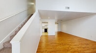 Located at 5292 SW 21st Pl in Ocala, Florida, this two-story home offers a well-organized layout with consistent finishes throughout. The main living area is generously proportioned, featuring warm hardwood-style flooring, soaring ceilings, and a classic fireplace as a focal point. High windows allow natural light to fill the space, enhancing its open and airy feel. Vertical blinds provide privacy while maintaining brightness. A staircase leads to the upper level, adding to the home's multi-floor functionality.

The kitchen is efficiently designed with white cabinetry, mosaic tile backsplash accents, and light countertops. Black appliances—including a range, dishwasher, and built-in microwave—provide a clean contrast against the bright cabinetry. Light tile flooring completes the practical yet attractive kitchen space.

The bedrooms are found on both floors, each featuring hardwood-style flooring and windows that bring in natural light. The upper-level bedroom benefits from vaulted ceilings and a large closet, while other bedrooms include closets and ample wall space. Both bathrooms are finished with light tile flooring, white vanity cabinetry, mosaic tile backsplash details, and full tub-shower combinations, offering clean and functional layouts throughout.