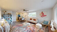 Located at 13418 Dottie Dr in Tampa, FL, this single-story, 3-bedroom, 1-bathroom home offers a well-organized and efficiently designed layout. Light wood-style flooring flows throughout the home, creating a warm and cohesive aesthetic.

The living room is bright and inviting, benefiting from multiple large windows that flood the space with natural light and offer views of the surrounding greenery. A ceiling fan adds to the comfort of the room, which features a textured ceiling and a welcoming front entry door with a decorative transom window.

The galley-style kitchen has been thoughtfully updated with white shaker cabinetry, contrasting matte black hardware, white subway tile backsplash, sleek countertops, a deep basin sink with a modern black faucet, and stainless steel appliances. A windowed back door at the end of the kitchen allows additional natural light to enter.

All three bedrooms are comfortably sized and include ceiling fans. The primary bedroom features a sliding-door closet and a wide window with outdoor views. The additional bedrooms are equally well-lit and share the home's consistent, clean aesthetic.

The full bathroom is finished in crisp white tile, featuring a tub-shower combination, a small privacy window, and light wood-style flooring. A hallway and closet complete the functional layout of this charming Tampa home.
