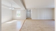 Located at 1401 Jorpark Cir in Spencerport, NY, this single-story home offers a practical and comfortable layout across three bedrooms and two full bathrooms. The open entryway welcomes you into a bright, carpeted living area that benefits from natural light streaming through large windows and sliding glass doors that offer views of the outdoors. The kitchen is well-appointed with warm honey-toned wood cabinetry, light countertops, a double-basin sink, and white appliances including a dishwasher and range. Light tile flooring carries throughout the kitchen and wet areas, providing a clean contrast to the plush carpeting found in the living spaces and bedrooms. The primary bedroom is a comfortable retreat, accompanied by a dedicated walk-in closet fitted with wire shelving for organized storage. The two bathrooms are finished with light tile flooring, tub-shower combinations, and one features a wood-toned vanity with a wide mirror. A dedicated laundry room with utility hookups adds everyday convenience. The additional bedrooms are well-sized, each featuring carpet flooring and windows that bring in natural light. The home's neutral color palette and straightforward layout make it a versatile and functional living space.