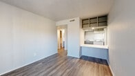 Located at 5318 S Hampton Rd in Dallas, TX, this single-story 2-bedroom, 3-bathroom unit offers a practical and functional layout across a compact footprint. The combined living and dining area serves as the heart of the home, featuring wood-look plank flooring, neutral gray walls, and a textured ceiling. A pass-through kitchen bar opens directly into this shared space, creating a connected feel. The kitchen is equipped with white appliances including a refrigerator, dishwasher, and range, complemented by marble-patterned countertops and gray cabinetry. A dedicated pantry provides additional storage. Both bedrooms are carpeted and feature vertical blinds that allow natural light to filter in. The primary bedroom offers a comfortable, private retreat. Three bathrooms serve the unit, with at least one featuring a marble-patterned vanity countertop and a tiled tub-shower combination. A central hallway connects the bedrooms and bathrooms, with multiple closets distributed throughout for ample storage. The unit also includes a front entry area with a large window, further brightening the interior with natural light.