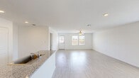 Located in a quiet New Braunfels, TX neighborhood, this single-story, 4-bedroom, 2-bathroom home offers a thoughtfully designed layout ideal for comfortable everyday living. The open-concept main area seamlessly connects the kitchen, dining, and living spaces, all bathed in natural light from large windows. Light wood-style flooring runs throughout, complementing the home's clean, bright aesthetic with crisp white walls and a textured ceiling.

The kitchen is well-appointed with tall white cabinetry reaching the ceiling, stainless steel appliances including a gas range, built-in microwave, and French door refrigerator, as well as granite-style countertops and a stainless steel sink. A convenient pantry and laundry room add to the home's practical storage and utility options.

The spacious primary bedroom features a generous walk-in closet with built-in shelving and rods. Additional bedrooms are well-proportioned, each with closets and windows providing natural light. The bathrooms are clean and functional, featuring tub/shower combinations.

A central hallway connects the bedroom wing to the main living areas. The home also includes an attached garage. Outside, the property sits on a well-maintained lot with a sizable backyard, manicured front landscaping, and street-facing curb appeal within a welcoming residential community.