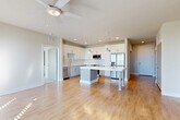 Located at 1464 Laurel Sound Lane in Sanford, FL, this well-appointed 2-bedroom, 2-bathroom residence offers a thoughtfully designed single-floor layout filled with natural light and modern finishes throughout. Light wood-tone flooring flows through the open-concept living, dining, and kitchen areas, creating a cohesive and airy atmosphere complemented by ceiling fans and recessed lighting.

The kitchen is a standout feature, showcasing white shaker cabinetry, a classic subway tile backsplash, light quartz countertops, a central island with pendant lighting, and a full suite of stainless steel appliances. This space connects seamlessly to the dining and living areas, making it ideal for entertaining.

Both bedrooms are carpeted and bathed in natural light from large windows with blinds. The primary bedroom includes a walk-in closet with wire shelving and access to a spa-inspired en-suite bathroom featuring a dual-sink vanity with dark countertops, illuminated mirrors, and a glass-enclosed tile shower.

A versatile den adds flexible living space, while a dedicated laundry area and multiple closets provide ample storage. The private balcony offers picturesque views of a nearby pond and lush greenery, adding a serene outdoor retreat to this polished Sanford residence.