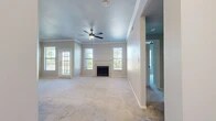 Located at 5511 Sedalia Trail in Benbrook, TX, this two-story home offers a well-organized layout across two floors, with the main living spaces comprising the majority of the home's footprint. The ground level includes an attached single-car garage equipped with an automatic opener, providing secure and convenient parking or additional storage.

The primary living floor features an open-plan living room and kitchen area bathed in natural light from multiple windows fitted with blinds. The spacious living room is anchored by a classic fireplace and finished with plush wall-to-wall carpeting, crown molding, and a ceiling fan. A rear door provides direct outdoor access. The adjacent kitchen offers warm oak cabinetry, dark granite-style countertops, hardwood-style flooring, a double-basin sink, and black appliances including a range, built-in microwave, and dishwasher.

The home includes three carpeted bedrooms, one of which features mirrored sliding closet doors. Two full bathrooms serve the home, one featuring a tiled tub-shower combination with hardwood-style flooring. A dedicated laundry closet with built-in shelving accommodates a full-size washer. Two hallways and two staircases connect the floors, ensuring a functional and efficient flow throughout the home.