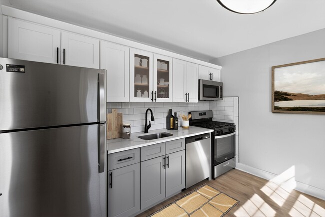 Descubra el encanto moderno de los apartamentos Eagle Rock en Woodbury. Esta impresionante cocina cuenta con elegantes electrodomésticos de acero inoxidable, gabinetes modernos y amplio espacio para dar rienda suelta a su creatividad culinaria. Mejore su calidad de vida hoy mismo: ¡programe una visita y compruébelo usted mismo! - Eagle Rock Apartments at Woodbury
