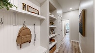 Located on Congress Street in Savannah, GA, this well-appointed single-floor residence offers three bedrooms and two bathrooms within a thoughtfully designed layout. The open-concept kitchen serves as the heart of the home, featuring crisp white shaker cabinetry, subway tile backsplash, stainless steel appliances, and a generous granite-topped island illuminated by striking black-and-gold pendant lights — ideal for both meal prep and casual dining. The living room is bathed in natural light from multiple large windows and features light wood-style flooring that extends throughout the main living areas. The primary bedroom is a comfortable retreat with plush carpeting and a bold accent wall, while additional bedrooms offer natural light and ample space. Both bathrooms are finished with granite countertops, white cabinetry, and glass-enclosed showers. A well-organized hallway features built-in open shelving and wall hooks, providing practical everyday storage without sacrificing style. Neutral tones, recessed lighting, and clean architectural lines create a cohesive, modern aesthetic throughout the entire space, making it a polished and functional home in the heart of Savannah.