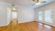 This single-story residence offers 840 square feet of efficiently designed living space. The home features three bedrooms, including a spacious primary bedroom of 170 square feet, and one full bathroom. The open-concept layout combines the kitchen and living room, creating a sense of spaciousness and flow.

Throughout the home, gleaming hardwood floors add warmth and elegance. Large windows with horizontal blinds allow for abundant natural light and privacy control. The kitchen is equipped with modern stainless steel appliances, including a refrigerator, stove, and built-in microwave. Rich wood cabinetry provides ample storage, complemented by light-colored countertops.

Each bedroom is equipped with a ceiling fan for comfort and features a closet for storage. The bathroom showcases a combination tub-shower unit with built-in shelving, a single vanity with under-sink storage, and continues the hardwood flooring theme.

The property's neutral color palette and clean lines create a contemporary aesthetic, suitable for a variety of personal styles. This compact yet well-designed home offers practical living spaces ideal for individuals or small families seeking a low-maintenance lifestyle.