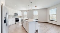 Located at 1400 Henderson Street in the heart of Fort Worth, TX, this 2-bedroom, 3-bathroom residence offers a well-designed, single-floor layout with modern finishes throughout. The open-concept living area seamlessly connects the kitchen, dining, and living spaces, all finished with light hardwood-style flooring that enhances the bright, airy atmosphere. The kitchen is a standout feature, equipped with stainless steel appliances, crisp white cabinetry, a herringbone tile backsplash, and a large center island with a built-in sink and pendant lighting above — ideal for both cooking and entertaining. The living area benefits from an expansive bank of windows that frame views of the Fort Worth skyline, flooding the space with natural light. A private balcony extends the living space outdoors. The primary bedroom is generously sized with plush carpeting and access to a well-appointed walk-in closet featuring multi-tiered shelving and hanging rods. The second bedroom is equally comfortable, also carpeted and filled with natural light. Three full bathrooms feature wood-tone flooring, white cabinetry, and clean modern fixtures. A dedicated utility room and additional closet storage round out this thoughtfully planned urban residence.