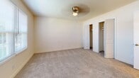 Located at 200 Mitchell Rd in Greenville, SC, this single-floor unit offers a clean, functional layout with a cohesive design throughout. The spacious living area welcomes you through a six-panel front door flanked by two large windows fitted with blinds, filling the room with natural light. Rich, dark hardwood-style flooring extends throughout the main living spaces, adding warmth and a polished look.

The galley-style kitchen is well-appointed with white cabinetry lining both walls, offering ample upper and lower storage. A stainless steel double-basin sink, granite-toned countertops, a white electric range, and a full-size refrigerator with over-range ventilation complete this efficiently designed space. A door at the end of the kitchen provides additional access.

The bedroom features plush neutral carpeting, a ceiling fan with integrated lighting, and a set of bifold closet doors opening to generous storage space. The full bathroom is finished with hardwood-style flooring, a vanity with speckled countertops and white cabinetry, a large mirror, and a white tiled tub and shower combination. The overall palette throughout the unit is light and neutral, creating a bright, move-in-ready atmosphere.