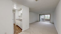 Located at 4061 Sharon Park Ln in Sharonville, Ohio, this single-floor, one-bedroom, one-bathroom unit offers a practical and well-organized layout. The living area is generously proportioned, featuring soft wall-to-wall carpeting, bright white walls, and a sliding glass door that opens to a private balcony with outdoor views — allowing natural light to fill the space. The open flow between the living area and hallway creates a connected, easy-to-navigate floor plan. The bedroom is a comfortable size, appointed with the same plush carpeting, a window with blinds for natural light and privacy, and a dedicated closet for storage. A textured ceiling adds subtle character to the room. The bathroom is finished in a crisp, all-white palette, featuring a full-size tiled tub and shower surround, small-format mosaic tile flooring, a vanity with counter space, and a lighted mirror — all contributing to a clean, functional aesthetic. Throughout the unit, the neutral color scheme and consistent finishes create a cohesive and move-in-ready environment suitable for a range of furnishing styles.