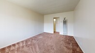 Located at 12036 S Vermont Ave in Los Angeles, CA, this one-bedroom, one-bathroom unit offers a practical and functional layout across a single floor. The living room features warm carpeted flooring, a textured ceiling, and a ceiling fan with light fixture, creating a comfortable, well-ventilated space. A wall-mounted heater provides additional climate control. The open dining and kitchen area flows naturally from the living space, finished with light tile flooring, white cabinetry, a tiled backsplash, a double-basin sink, and a ceiling fan overhead — keeping the area bright and airy. The bedroom is a comfortable, carpeted retreat with a ceiling fan, a large window dressed with vertical blinds that allows natural light in, and a built-in closet with overhead storage cabinetry. Three closets throughout the unit offer generous storage options. The bathroom includes tile flooring, a shower-tub combination enclosed by sliding glass doors, and a small window that provides natural ventilation. A hallway connects the main living areas, adding to the unit's efficient and well-organized flow. The textured ceilings and neutral wall tones throughout lend the space a clean, understated character.