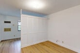 Located at 6460 Taft St in Hollywood, Florida, this single-floor, one-bedroom, one-bathroom unit offers a thoughtfully organized layout that makes efficient use of its compact footprint. Light wood flooring runs throughout the main living areas, providing warmth and visual continuity across the space.

The living room is bright and open, with a window that brings in natural light and a clean, minimalist design. A private entrance door adds a sense of independence to the unit. Adjacent to the living area, the kitchen features an L-shaped configuration with light oak wood cabinetry spanning both upper and lower sections, offering generous storage. White laminate countertops and a stainless steel sink complement the wood tones, while a full-size refrigerator is included.

The bedroom is a comfortable, well-proportioned space highlighted by wide, louvered bi-fold closet doors that span nearly the full width of one wall, providing ample wardrobe storage. A textured ceiling and a window round out the room. A dedicated closet area also houses a water heater and includes wire shelving overhead for additional storage.

The bathroom is fully tiled in classic white, featuring a tub and shower combination with a grab bar, a toilet, and a vanity. A window provides natural light and ventilation. The unit also includes a private patio, offering a convenient outdoor retreat.