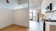 Located at 1129 Cherokee St in Denver's Lincoln Park neighborhood, this modern 1-bedroom, 1-bathroom residence showcases contemporary design throughout its efficiently laid-out single floor. Soaring ceilings with exposed concrete soffits lend an industrial-chic character, while light wood-tone flooring flows seamlessly across the living areas, kitchen, hallway, and bedroom.

The open kitchen is well-appointed with a full suite of stainless steel appliances — including a gas range, over-the-range microwave, dishwasher, and French door refrigerator — complemented by two-tone cabinetry in white and natural wood, a white subway tile backsplash, and sleek countertops. Floor-to-ceiling windows and a private balcony access point flood the kitchen and living area with natural light while offering elevated views of the Denver skyline.

The bedroom features soaring ceilings, a ceiling fan, and a large sliding closet with matte charcoal doors, providing ample storage alongside three total closets in the unit. The hallway connects all spaces efficiently and includes in-unit laundry. The bathroom is finished with a warm wood vanity, white countertop, a large mirror, and matte black fixtures. Clean white walls throughout maintain a bright, minimalist ambiance ideal for modern urban living.