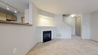 Located at 6108 Chestnut Ridge Dr in Columbus, Ohio, this two-story home offers four bedrooms and one bathroom across two thoughtfully laid-out floors. The main level features a carpeted living room anchored by a fireplace with a white mantel and a vaulted ceiling detail above, creating a welcoming focal point. Large windows along the front of the living area allow natural light to fill the space, with views of the surrounding exterior. The galley-style kitchen is efficiently designed with light wood cabinetry, gray laminate countertops, wood-look luxury vinyl flooring, track lighting, and white appliances including a range, refrigerator, and dishwasher. A utility room is accessible directly from the kitchen. The main level is completed by a staircase leading to the upper floor. Upstairs, four bedrooms are finished with neutral carpet and provide natural light through well-placed windows with blinds. The primary bedroom offers a comfortable, open layout. The shared full bathroom features a single-sink vanity with light wood cabinetry, a combination tub and shower, and wood-look flooring. A hallway connects the upper-level rooms. Throughout the home, neutral tones and consistent finishes create a clean, cohesive aesthetic.